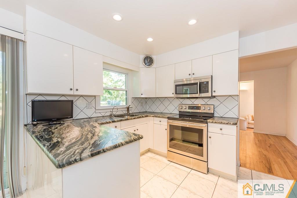 24 Taylor Road Princeton, NJ 08540 - Photo 6 of 25 a kitchen with granite countertop a sink stove and microwave