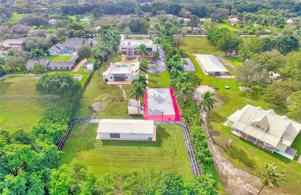 an aerial view of residential houses with outdoor space and swimming pool