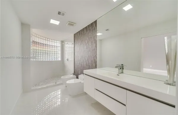 a bathroom with a double vanity sink toilet and shower