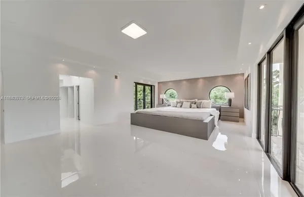 a bedroom with a bed lamps and a large mirror