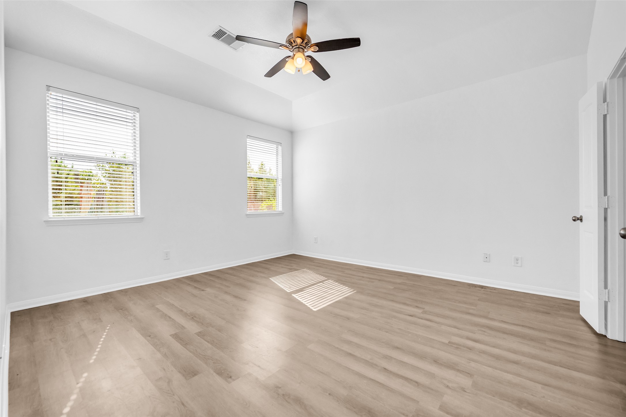 4707 Waukegan Road Conroe, TX 77306 - Photo 18 of 31 This unfurnished view of the primary bedroom highlights its open layout, with multiple doors providing convenient access to other areas of the home.