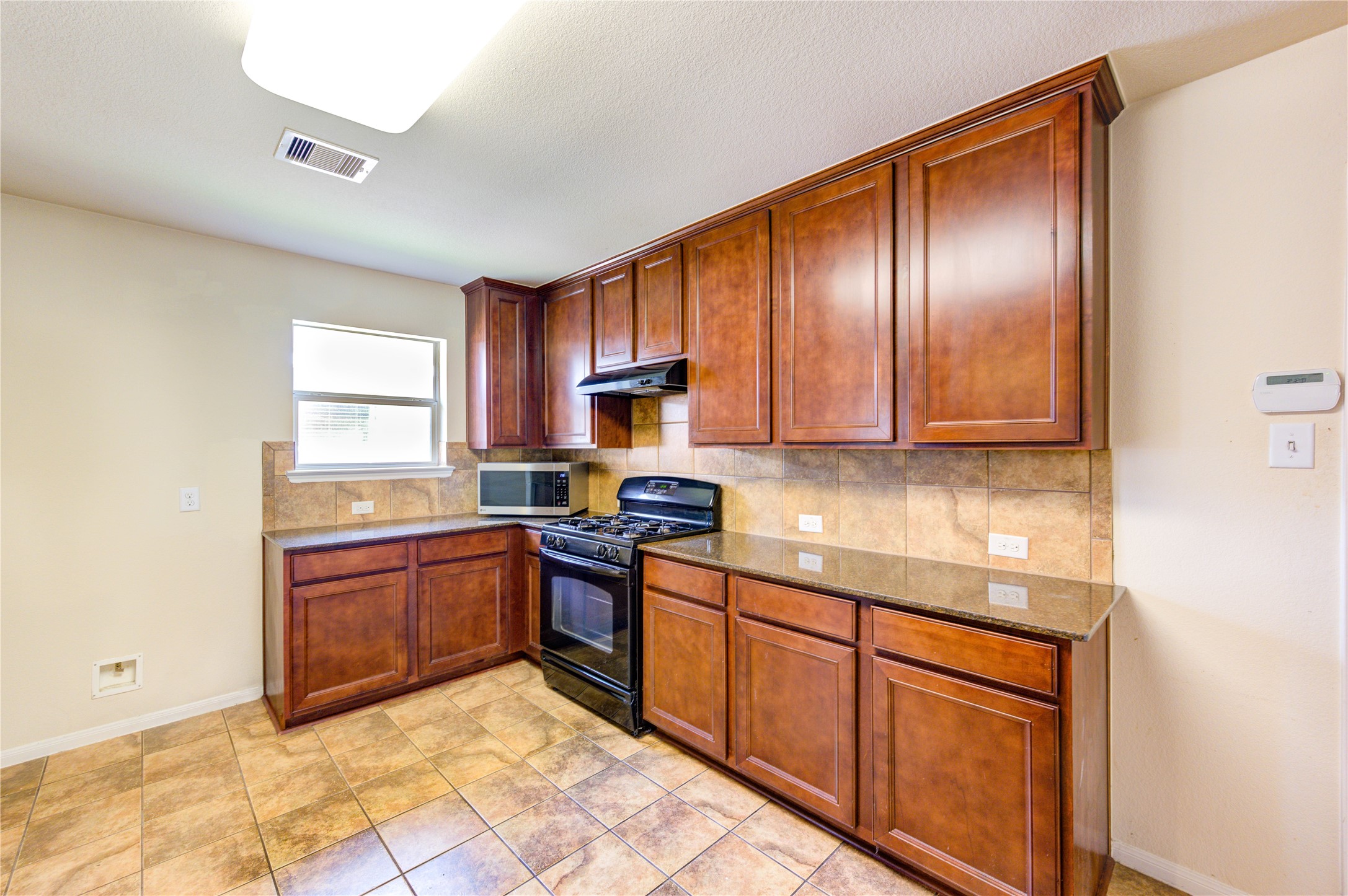 2922 Halcyon Time Trail Houston, TX 77045 - Photo 34 of 50 a kitchen with stainless steel appliances granite countertop wooden cabinets a stove top oven a sink and dishwasher