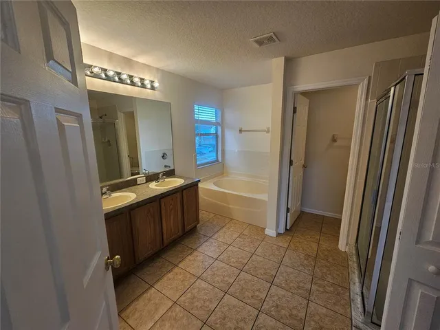 a large bathroom with a glass door shower a sink and a mirror