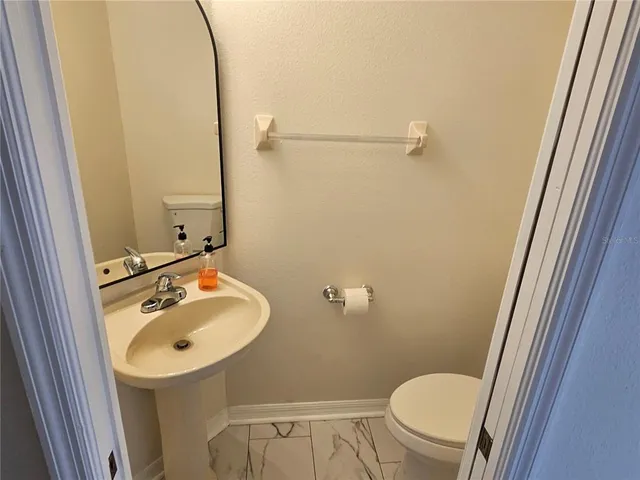 a bathroom with a sink a toilet and a mirror