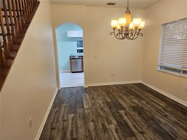a view of a livingroom with wooden floor and a kitchen