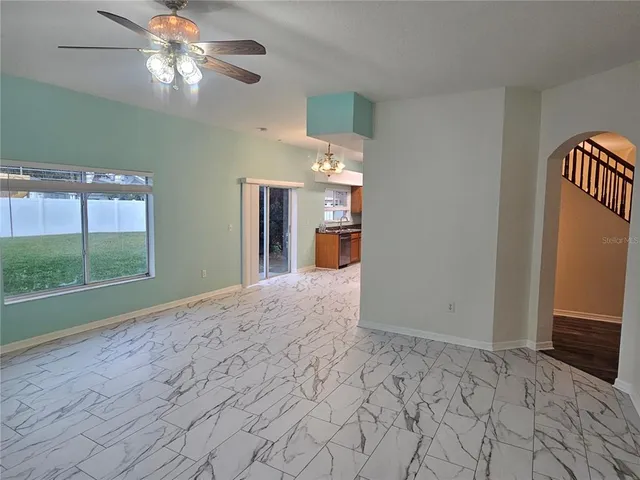 a view of a livingroom with a chandelier fan and a window