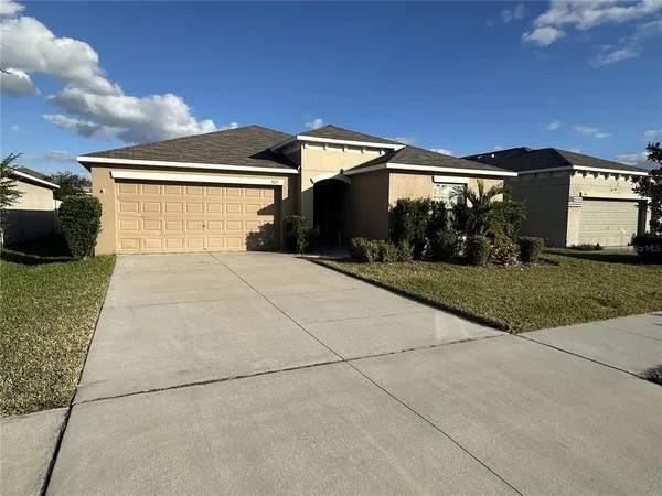 a view of a house with backyard and parking space