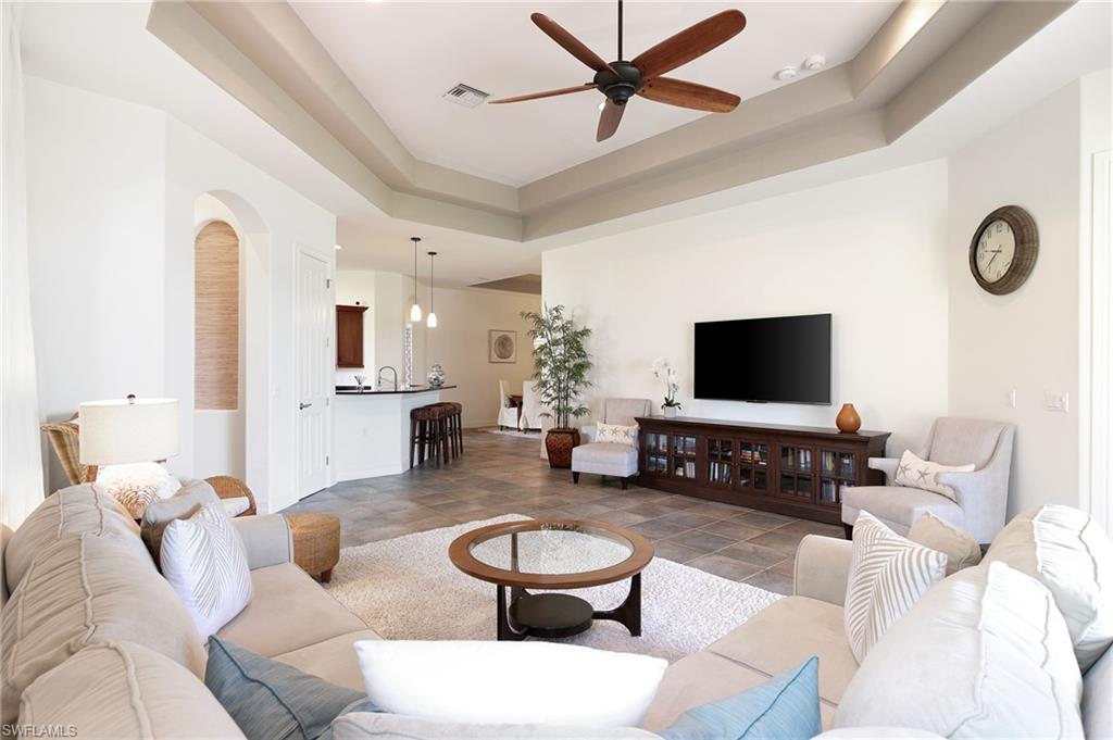 7563 Moorgate Point Way Naples, FL 34113 - Photo 14 of 40 a living room with furniture a flat screen tv and a large window