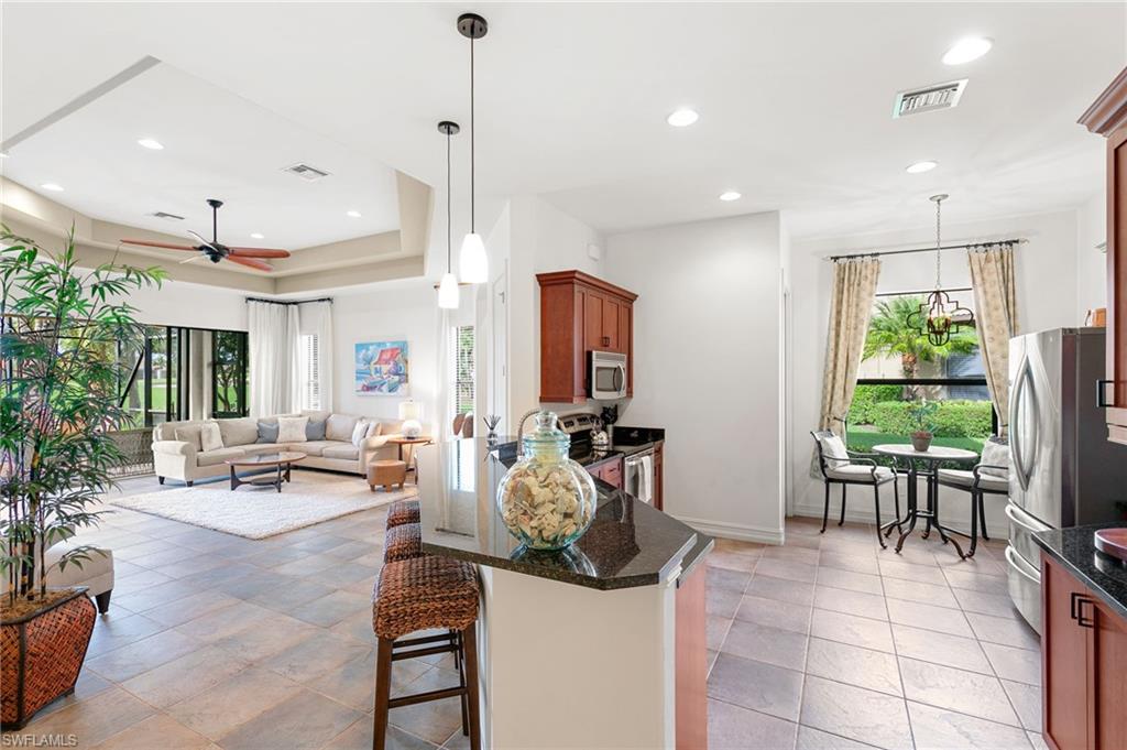 7563 Moorgate Point Way Naples, FL 34113 - Photo 16 of 40 a view of a dining room and livingroom with furniture wooden floor a chandelier