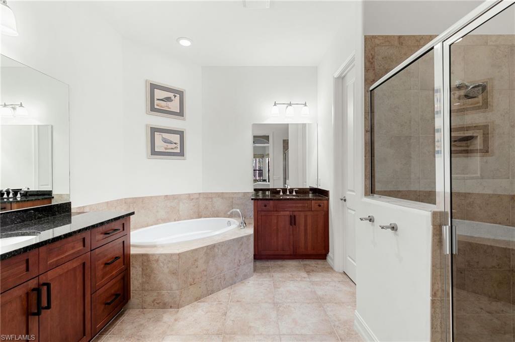 7563 Moorgate Point Way Naples, FL 34113 - Photo 24 of 40 a spacious bathroom with a tub sink and mirror