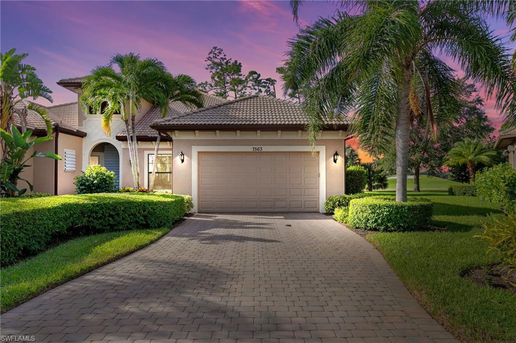 7563 Moorgate Point Way Naples, FL 34113 - Photo 8 of 40 a front view of a house with a yard and garage