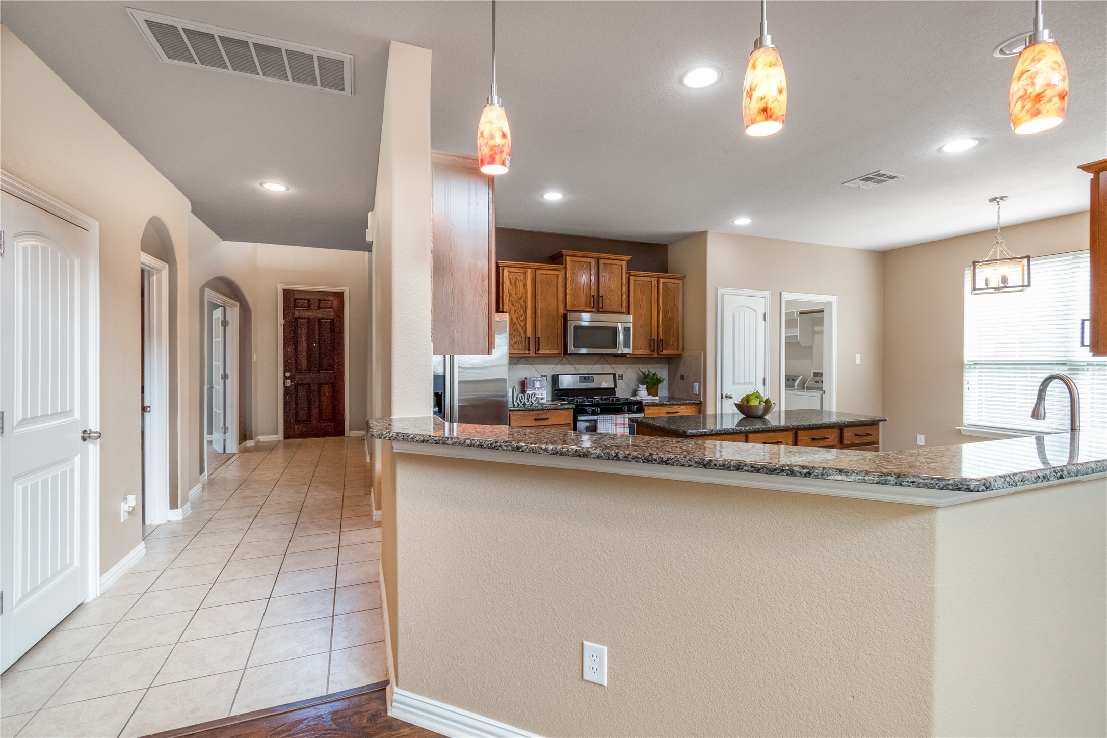 3413 Grail Hollows Road Pflugerville, TX 78660 - Photo 5 of 36 a kitchen with stainless steel appliances granite countertop a sink refrigerator and cabinets