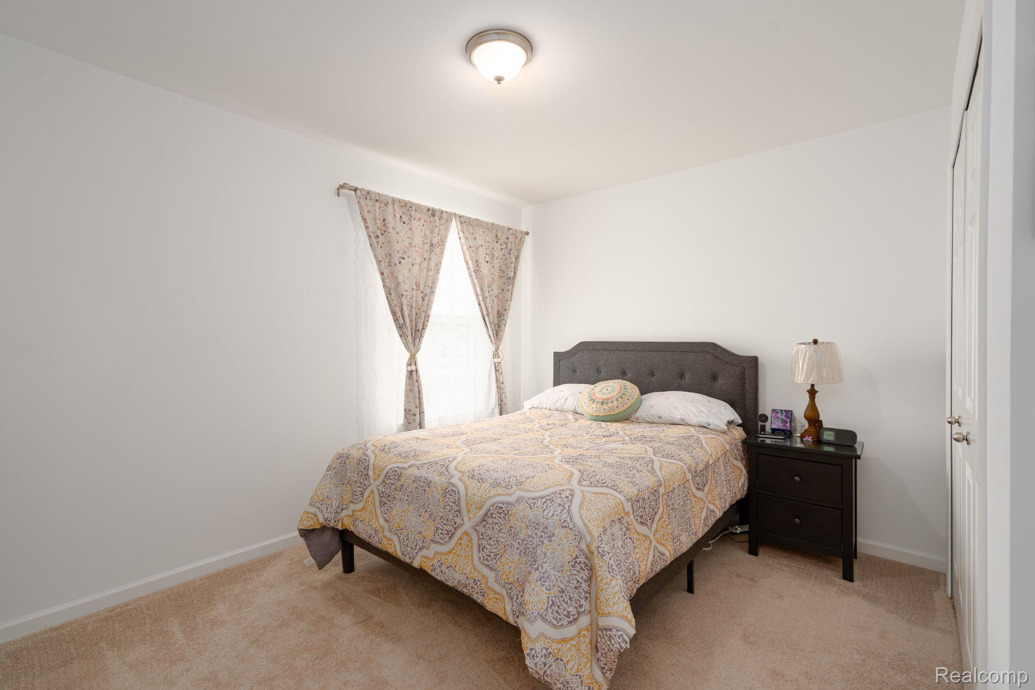 48904 Carnegie Way Macomb, MI 48042 - Photo 25 of 34 Neutral-toned carpeting extends throughout this room, featuring white walls and a ceiling-mounted light fixture