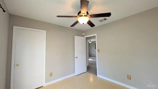 a view of a room with a chandelier fan and closet