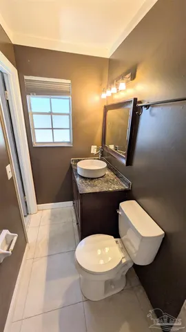 a bathroom with a sink a toilet a mirror and window