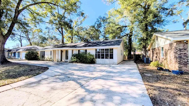 a view of a white house with a large tree