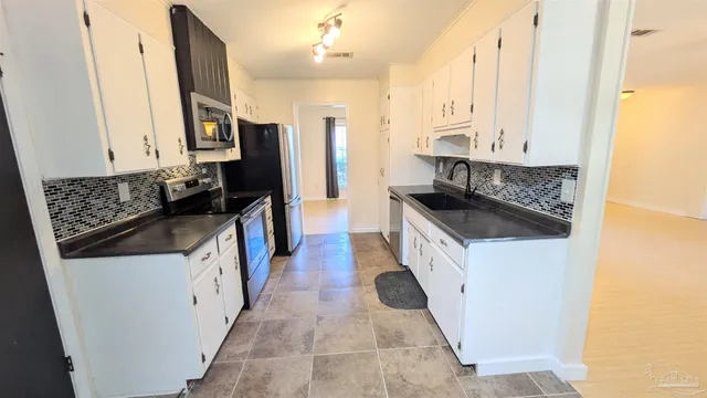 a kitchen with stainless steel appliances granite countertop a stove a sink and a refrigerator