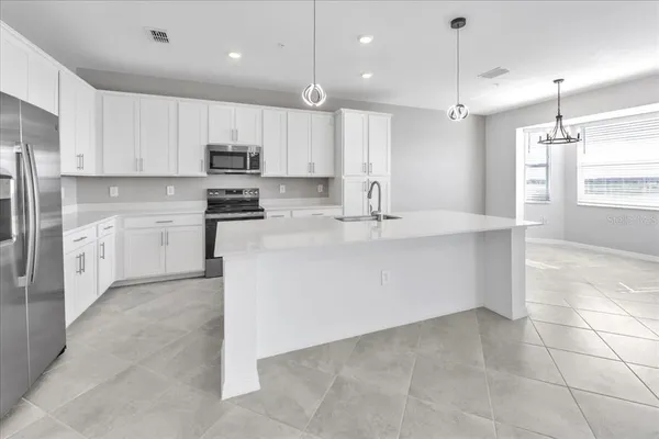 a kitchen with kitchen island a sink stainless steel appliances and cabinets