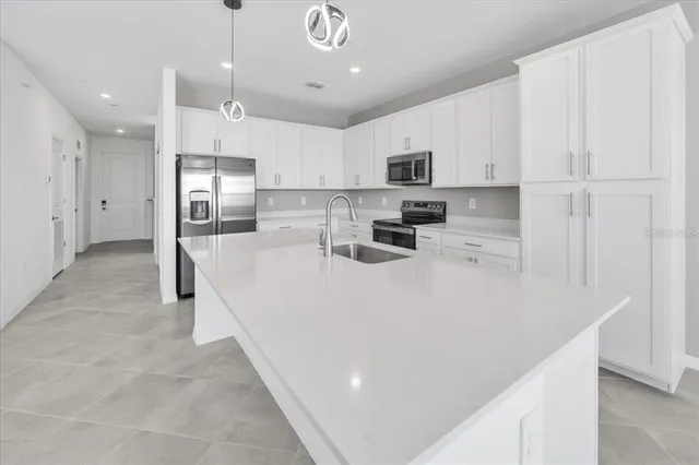 a large white kitchen with lots of counter space and appliances