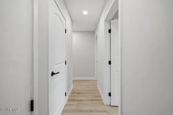 a view of a hallway with wooden floor and closet