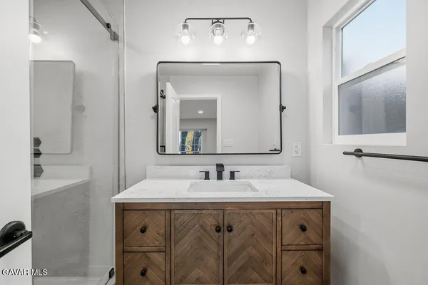 a bathroom with a sink vanity and a mirror