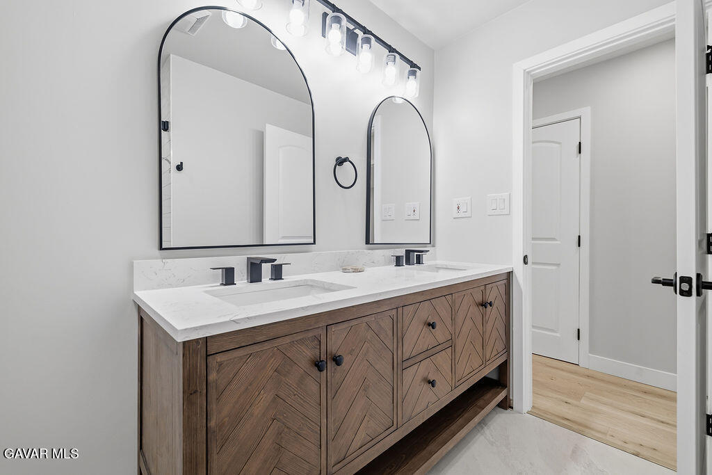 10557 Reseda Boulevard Porter Ranch, CA 91326 - Photo 22 of 37 a spacious bathroom with a double vanity sink and a mirror