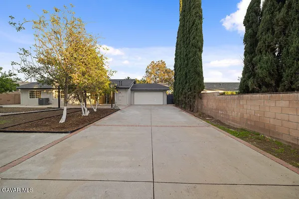 a front view of a house with yard and tree