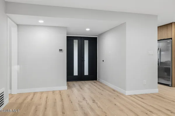 a view of hallway with a large window and wooden floor
