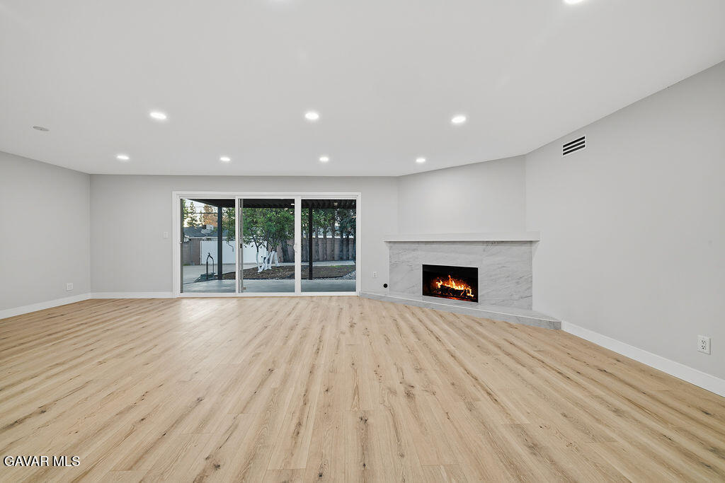 10557 Reseda Boulevard Porter Ranch, CA 91326 - Photo 6 of 37 a view of an empty room with wooden floor and a fireplace