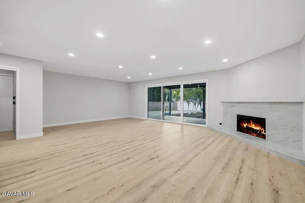 an empty room with windows and fireplace
