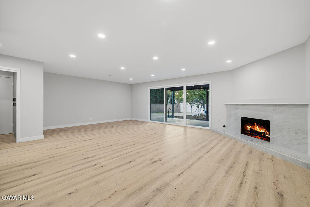 10557 Reseda Boulevard Porter Ranch, CA 91326 - Photo 7 of 37 an empty room with windows and fireplace