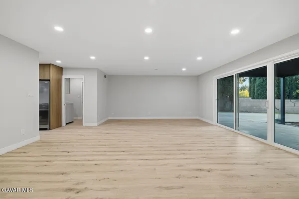a view of an empty room with wooden floor