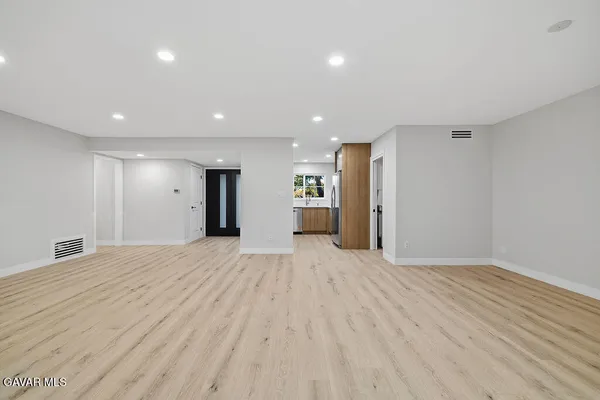a view of an empty room with wooden floor