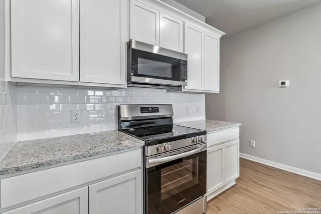 a kitchen with stainless steel appliances granite countertop a stove a microwave and a sink