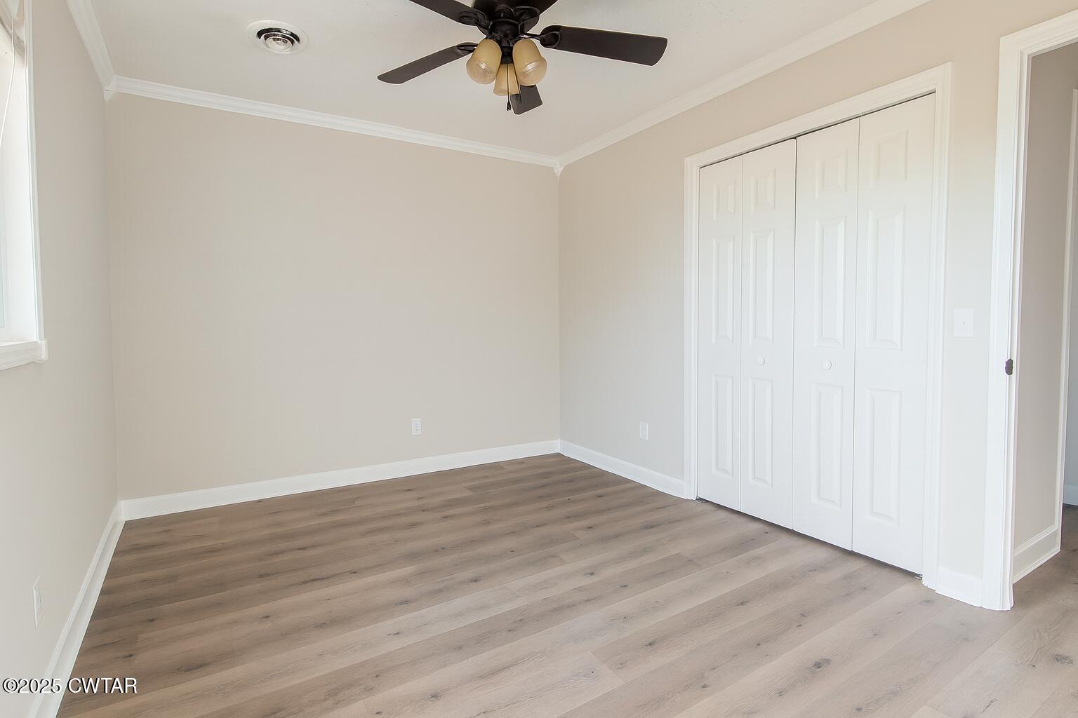 91 Currie Road Dyer, TN 38330 - Photo 8 of 13 an empty room with wooden floor fan and windows