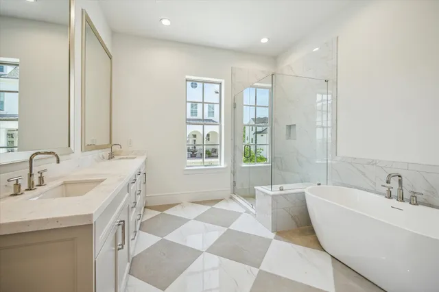a spacious bathroom with a double vanity sink a mirror and a bathtub