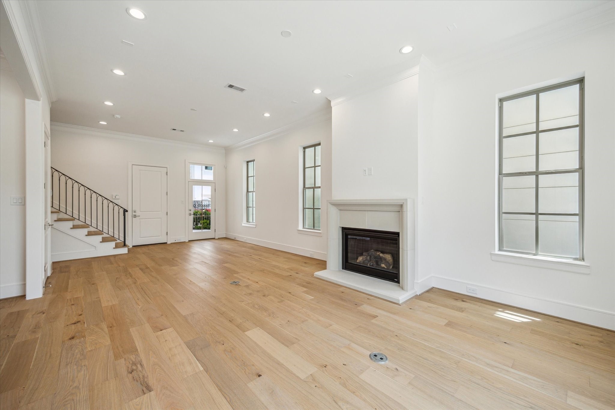 211 Sutton Row Place Houston, TX 77024 - Photo 3 of 25 an empty room with wooden floor fireplace and windows