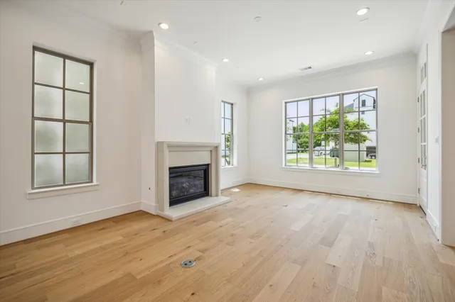 an empty room with windows and a fireplace