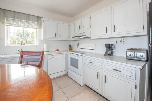 a kitchen with white cabinets and white appliances