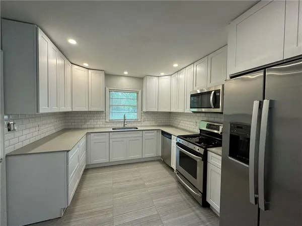 a kitchen with a sink stove and refrigerator