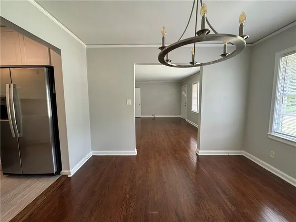 a view of a room with wooden floor table and windows
