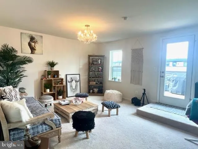 a living room with furniture a chandelier and a window