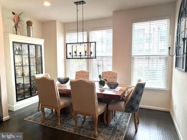 a dining room with furniture a chandelier and wooden floor