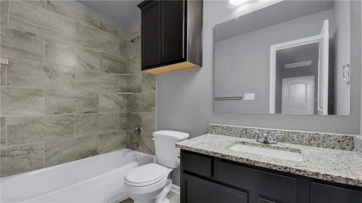 2106 Stubbs Drive Bryan, TX 77807 - Photo 5 of 11 a bathroom with a granite countertop sink a toilet and bathtub