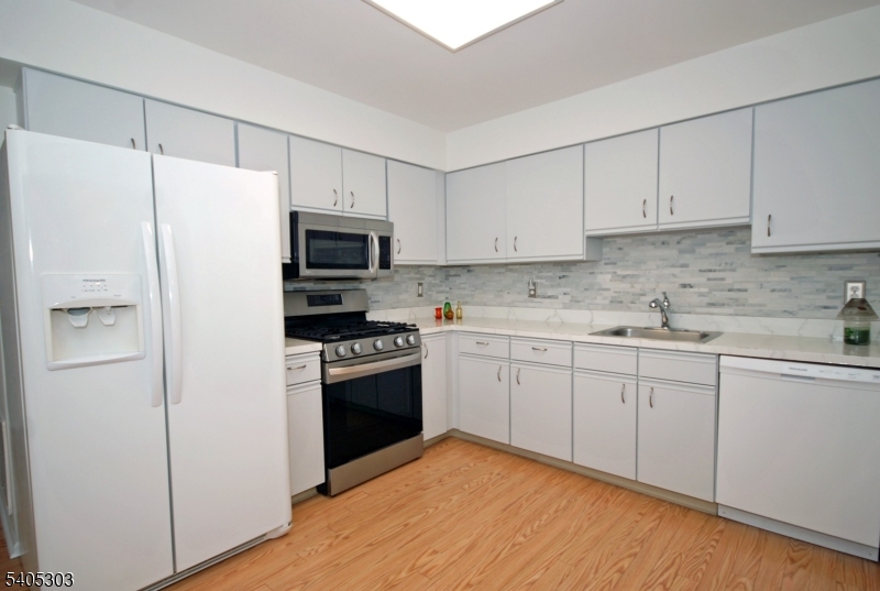 10 Apache Way Somerville, NJ 08876 - Photo 11 of 37 a kitchen with granite countertop white cabinets and white stainless steel appliances