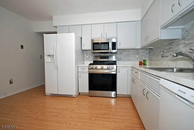 a kitchen with stainless steel appliances a refrigerator stove and sink