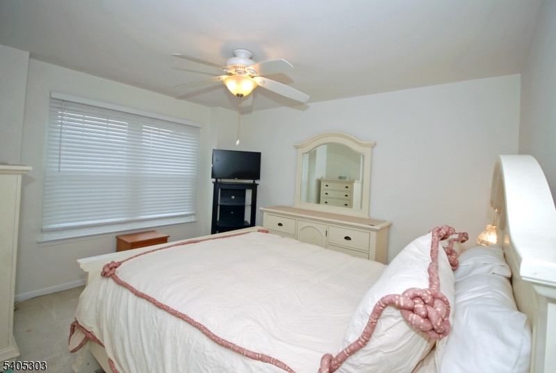 10 Apache Way Somerville, NJ 08876 - Photo 27 of 37 a bedroom with a bed and a chandelier