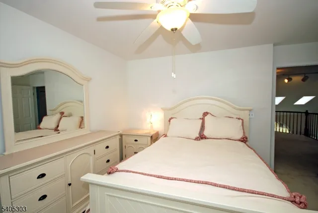 a bedroom with a bed and a mirror on the dresser