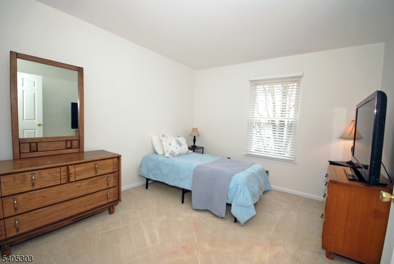 10 Apache Way Somerville, NJ 08876 - Photo 30 of 37 a spacious bedroom with a bed and a flat tv screen on a dresser