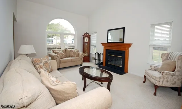 a living room with furniture a fireplace and a large window